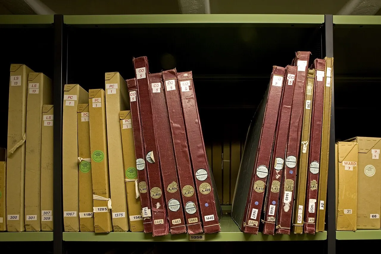 Rows of archived document boxes on repository shelving.