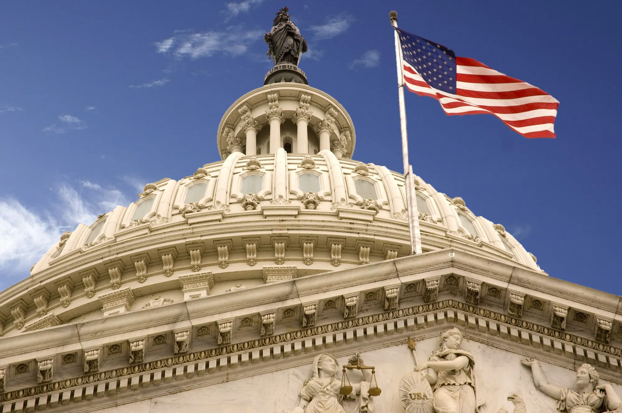 The United States Capitol dome beneath an American flag.